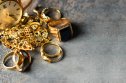 Gold jewellery An assortment of gold jewellery lying on a grey background