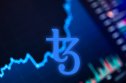 Tezos (XTZ) price prediction the Tezos (XTZ) logo in blue on a dark blue background with finance graph
