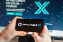 Immutable X Price Prediction: What's Next for This Gaming-Focused Protocol?  Logo, Immutable X screenshot, IMX token.  Blockchain nft ethereum cryptocurrency game in laptop, mobile phone.  Man playing with crypto coins.