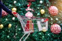 top 10 retail stocks Christmas shopping - a woman shopper with bags in a basket on a festive ornament and a Christmas tree on a street background