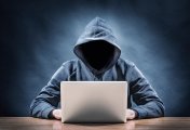 Hacker Man in hoodie sitting at laptop