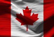 CAD is a star performer amongst the commodity block currencies – but might falling oil prices hit CAD sooner not later? Canadian Flag in shadow - stock photo