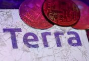 Terra Terra logo displayed on a phone screen is seen through a broken glass with representation of cryptocurrency in this illustration photo