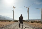 Wind Farm A businessman at a wind farm with a gasoline pump in his hand.