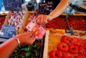 A file photo of a shopper paying with a ten Euro bank note at a local market in Nice, France, June 7, 2022. A file photo of a shopper paying with a ten Euro bank note at a local market in Nice, France, June 7, 2022.