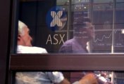 A file photo shows a pedestrian reflected in a window where an investor sits looking at a board displaying stock prices at the Australian Securities Exchange (ASX) in Sydney, Australia February 9, 2018. A file photo shows a pedestrian reflected in a window where an investor sits looking at a board displaying stock prices at the Australian Securities Exchange (ASX) in Sydney, Australia February 9, 2018.