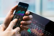 NSE Nifty 50 stock trader using mobile handset for a transaction