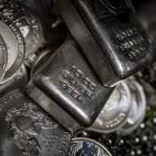 A pile of Silver bullion bars and coins against a dark background