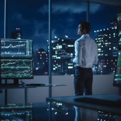 A financial trader surrounded by multiple screens