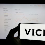 VICI Properties shareholders Person holding cellphone with logo of US real estate company Vici Properties Inc. on screen in front of business webpage. Focus on phone display
