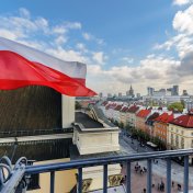 Poland interest rate forecast for next 5 years The flag of Poland in the Blue sky and the center of Warsaw in the background