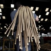 A file photo shows an employee carrying copper hoses at the Sociedade Paulista de Tubos Flexiveis (SPTF) metallurgical company which manufactures flexible metal hoses, in Sao Paulo April 20, 2012. 