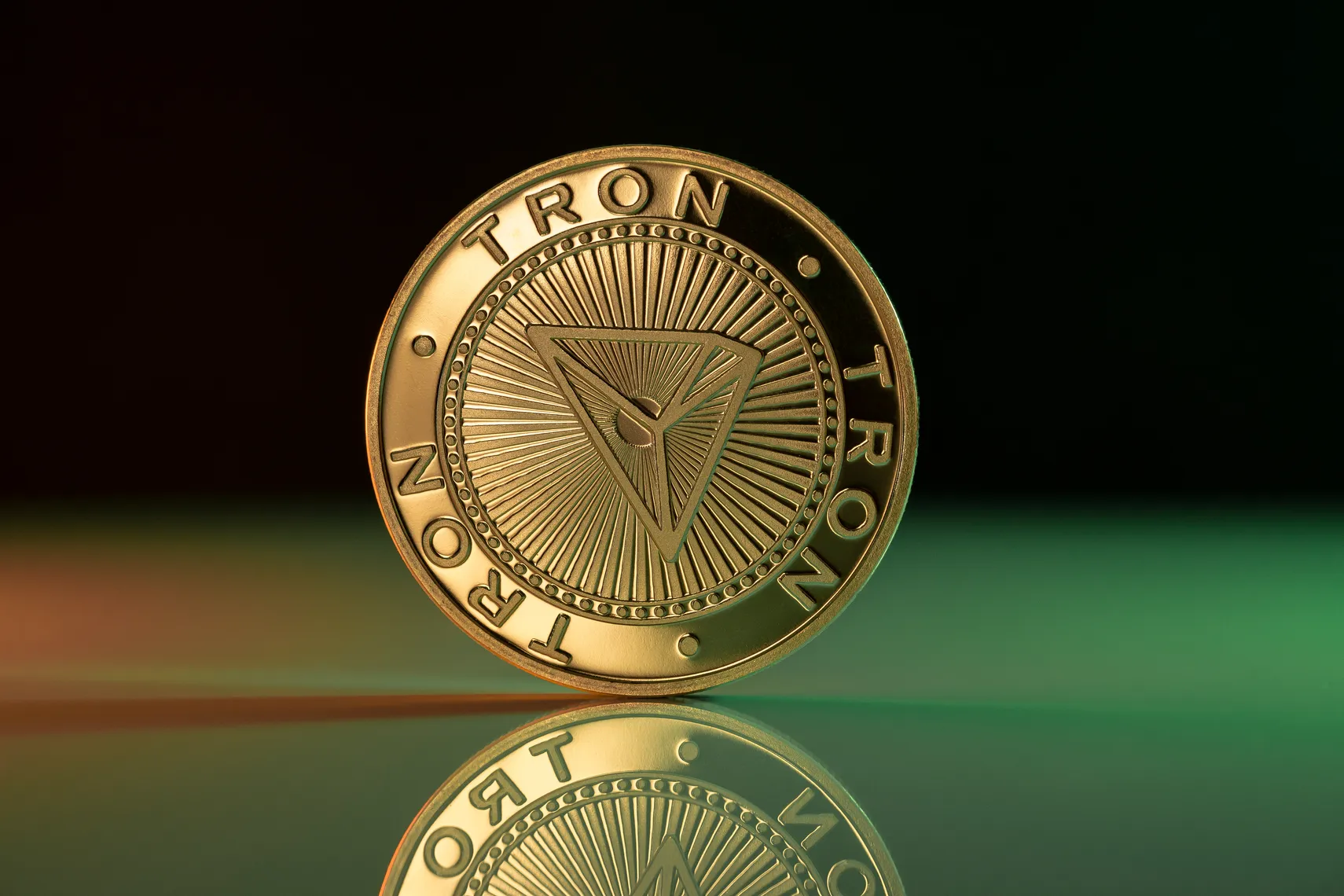 Tron price prediction Tron price prediction. Tron TRX cryptocurrency physical coin placed on reflective surface and lit with green and red lights