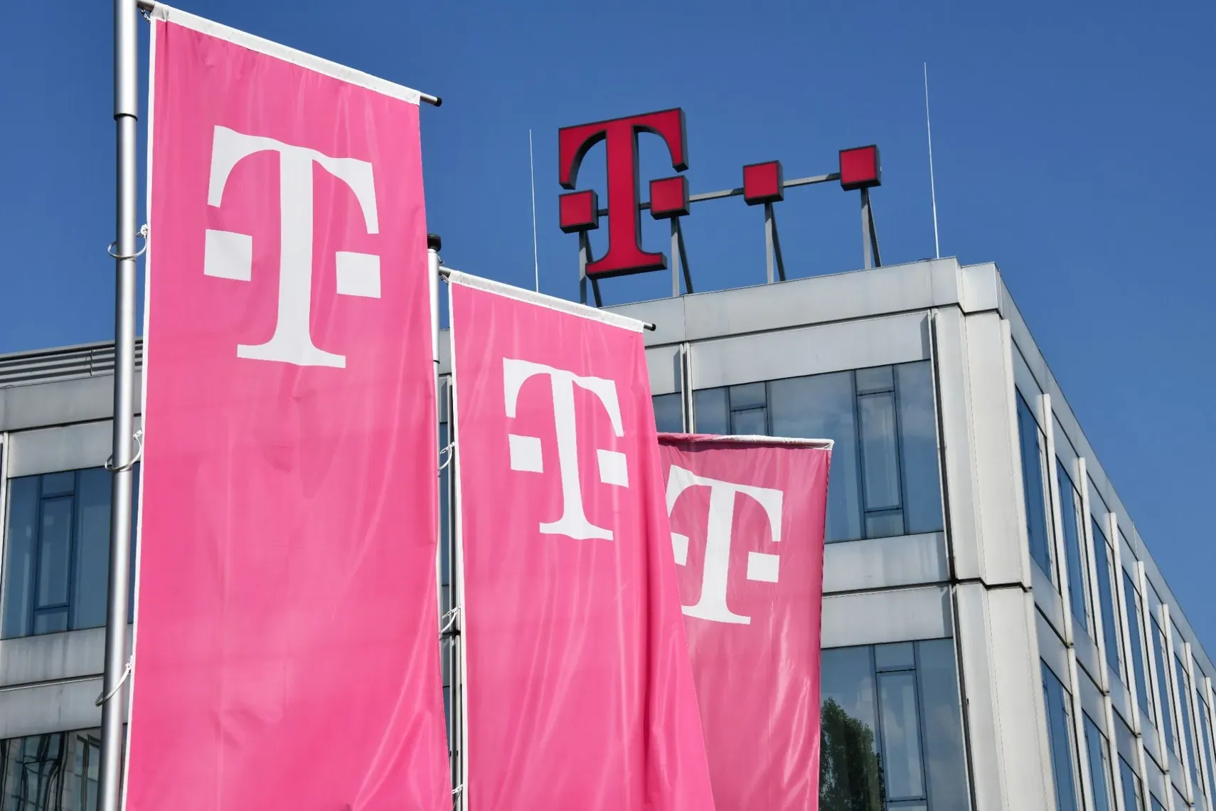 Deutsche Telekom Flaggen und Logo an moderner Bürogebäudefassade