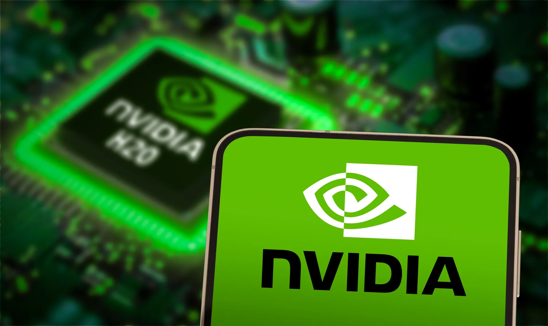 Nvidia logo displayed on a smartphone in front of an Nvidia-branded computer chip Nvidia logo displayed on a smartphone in front of an Nvidia-branded computer chip