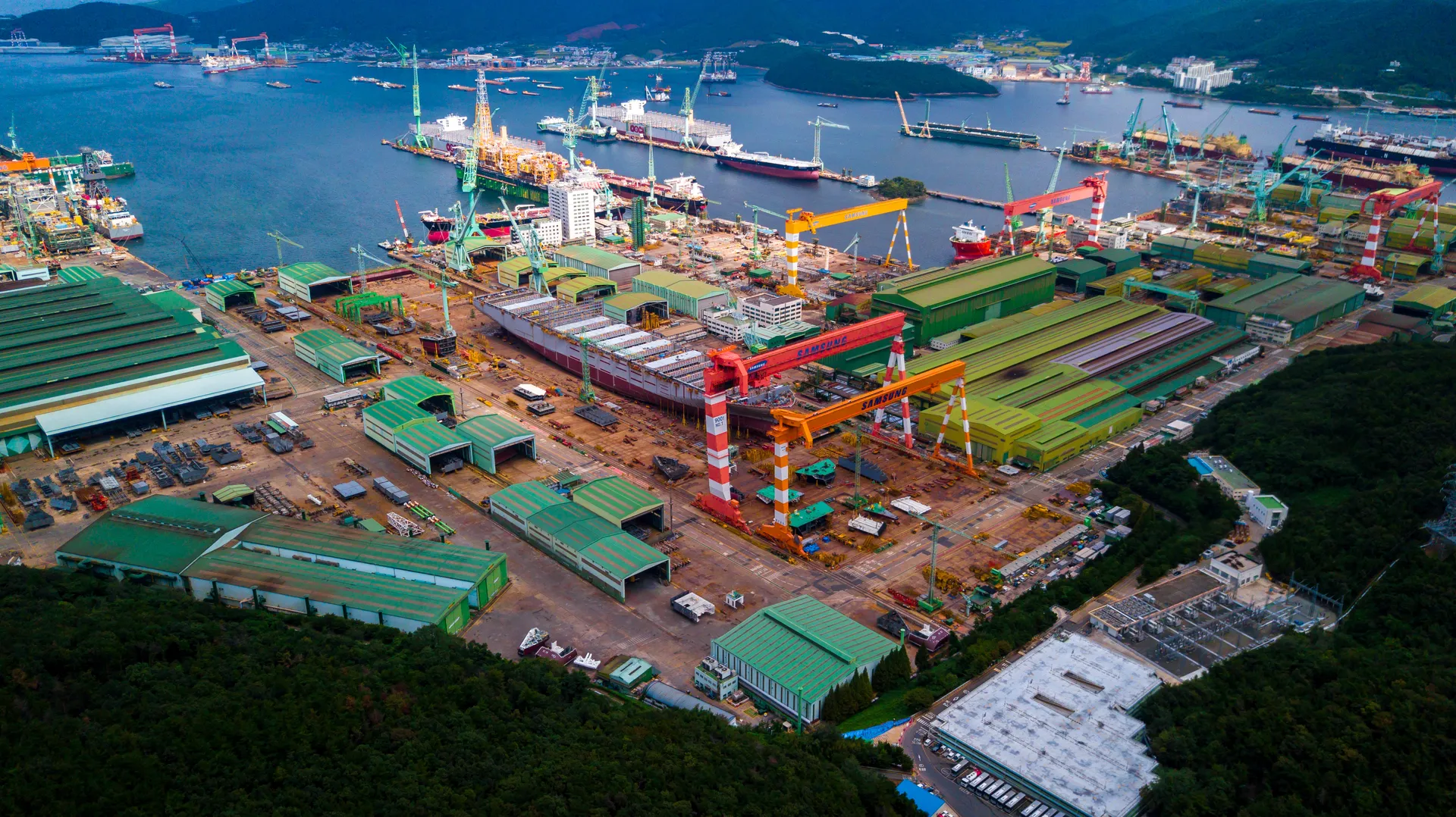 Aerial view of a large shipyard with cranes and vessels under construction. Aerial view of a large shipyard with cranes and vessels under construction.