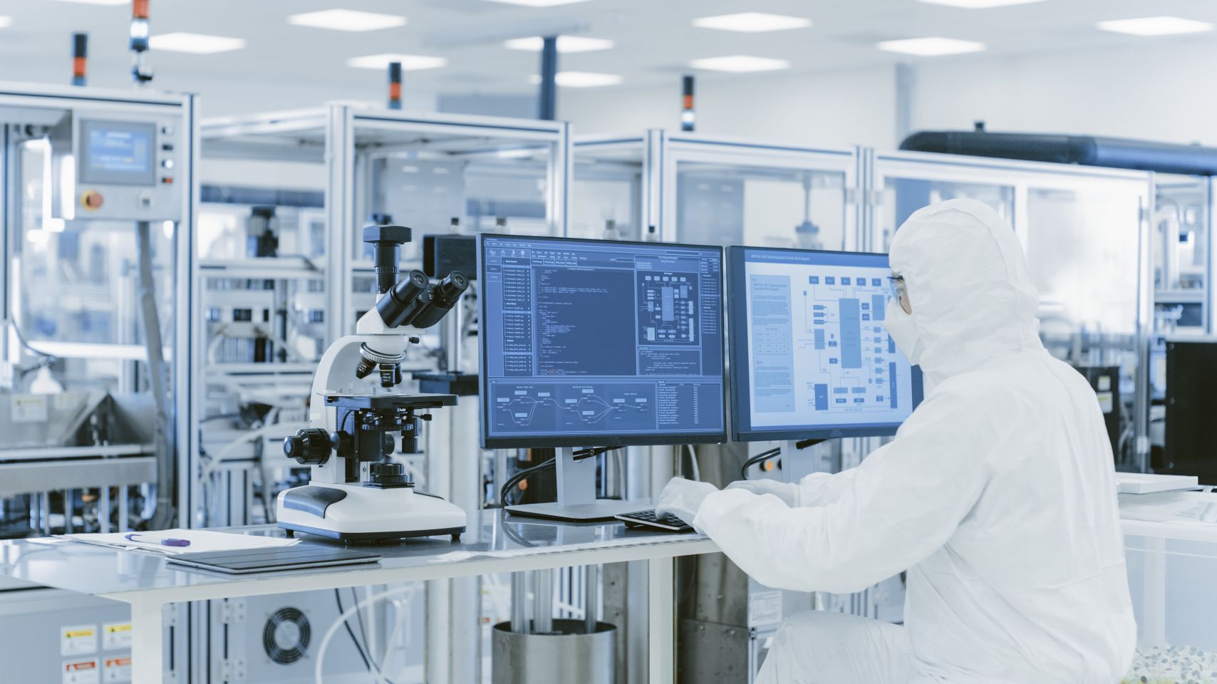 Over the shoulder view of a scientist in protective clothes in a laboratory