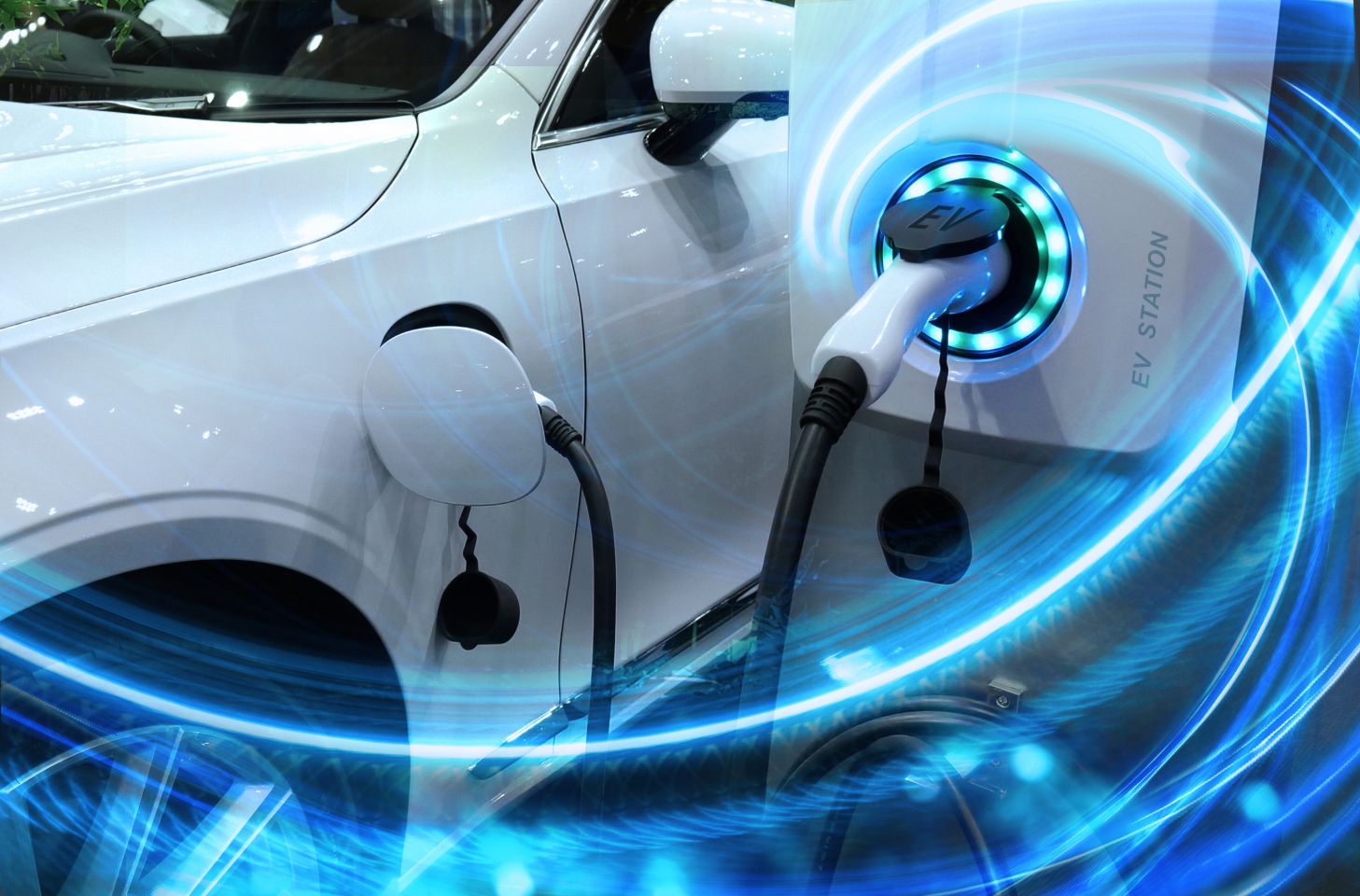 Electric vehicle at charging station with the power cable supply plugged in owith 