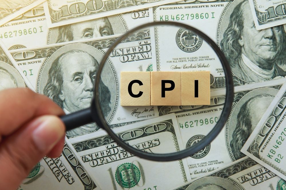 hand holding magnifying glass investigating wooden block with words CPI, consumer price index on dollar bills. hand holding magnifying glass investigating wooden block with words CPI, consumer price index on dollar bills.