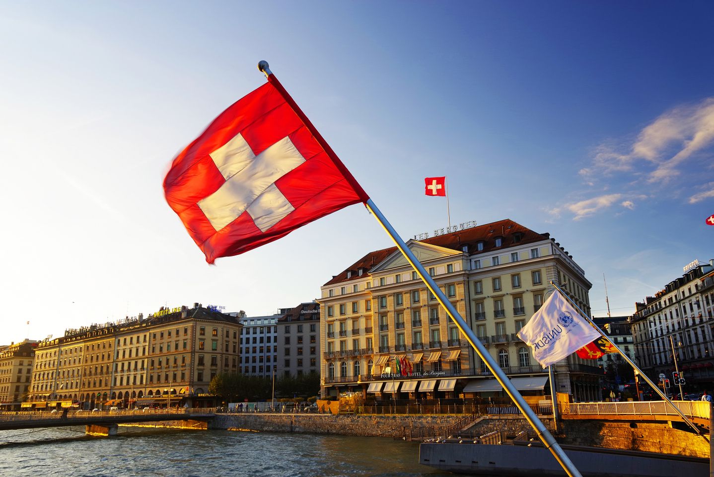 Flag of the Geneva Canton and flag of Switerland in the city center of Geneva on the Mont Blanc Bridge