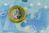 GBP/EUR forecast One pound coin on top of 20 Euros banknote, next to a map of the EU