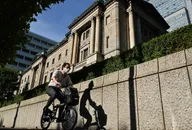 A man bicycles past the Bank of Japan headquarters buildings in Tokyo