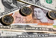 US dollar bills with British £1 coins and notes
