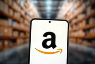 Amazon-Logo auf einem Smartphone-Bildschirm mit unscharfem Lagerhintergrund