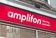 Logo Amplifon su una vetrina, che rappresenta il fornitore globale di soluzioni per l'udito e apparecchi acustici.