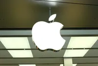 Beleuchtetes Apple-Logo an der Außenfassade eines modernen Einzelhandelsgeschäfts