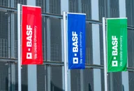 BASF company flags in red, blue, and green displayed outside an industrial building