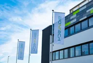 BioNTech-Flaggen vor einem modernen Bürogebäude