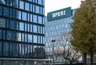 Logo BPER esposto sul tetto di un moderno edificio per uffici con facciate in vetro.
