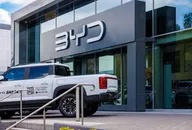 BYD-Showroom von außen mit einem weißen elektrischen Pickup-Truck vor einem modernen Glasgebäude