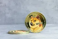 Physische Dogecoin-Münzen mit dem Shiba-Inu-Hunde-Logo, eine stehend und eine liegend
