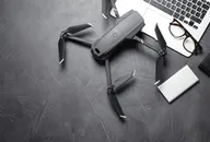 Consumer-style drone placed on a desk beside a laptop, representing the growing UAV and counter-drone technology market