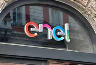 Enel logo displayed on the glass facade of a building under a stone arch