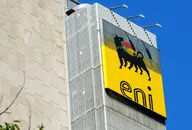 Logo Eni su insegna gialla montata su edificio per uffici moderno contro cielo azzurro