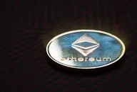 Ethereum coin with the ETH logo on a dark background.