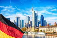 Frankfurter Skyline mit modernen Wolkenkratzern des Finanzviertels und deutscher Flagge, repräsentiert den Germany 40 (DAX) Index