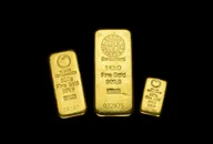 Three gold bullion bars of different sizes displayed on a black background.