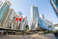 Skyline del distretto finanziario di Hong Kong con moderne torri per uffici e bandiere vicino a Exchange Square