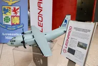 Modello di aereo militare esposto accanto al logo Leonardo durante una presentazione nel settore della difesa e aerospazio