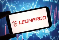 Leonardo logo displayed on a smartphone screen with stock market charts in the background.