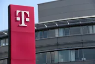 DTE-Logo auf einem roten Firmenschild vor einem modernen Bürogebäude