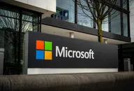 Microsoft logo displayed outside a modern office building, representing the global technology company and its corporate headquarters.