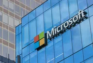 Microsoft-Logo an der Fassade eines modernen Glasbürogebäudes