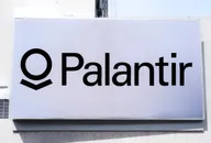 Palantir logo displayed on a large white sign on a building exterior.