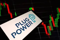 Plug Power logo displayed on a smartphone screen with stock market candlestick chart in the background