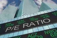 Electronic stock market ticker displaying financial quotes in front of modern skyscrapers, representing global financial markets, trading activity, and investment performance. 